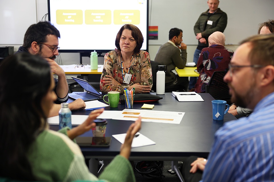 ALT workshop participants, discussing around a table.