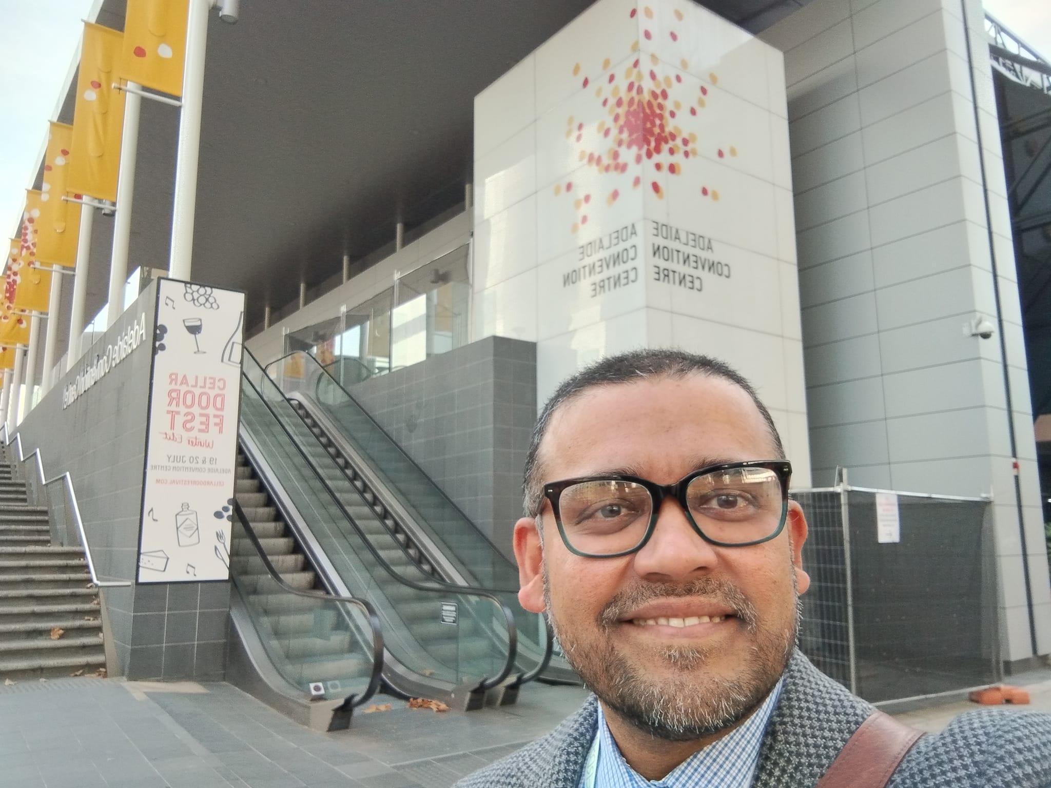 Sean Perera standing in front of the Adelaide Convention centre where the HERDSA conference was held